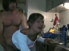 In the kitchen, a tongue cumshot and brutal sex are performed on a cute blonde wife with short hair.